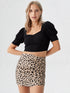 Close-up of woman wearing black sweetheart neck puff sleeve crop top with printed skirt