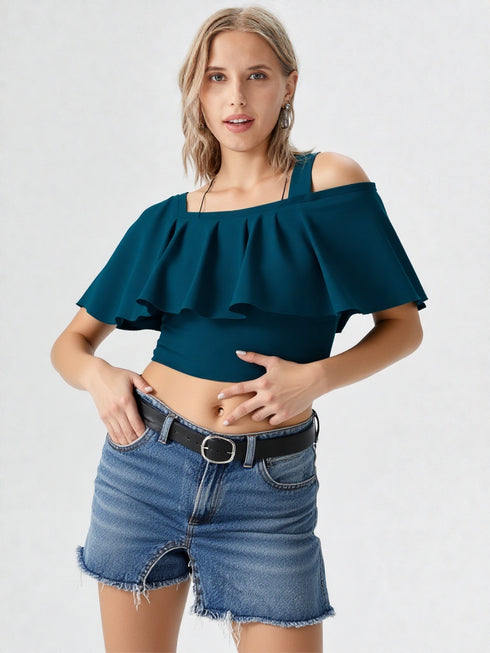 Woman wearing teal one-shoulder ruffle crop top with belted jeans