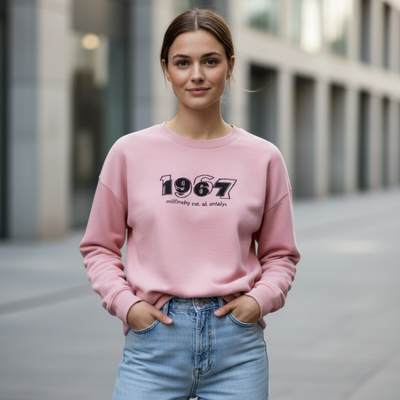 Pink cotton sweatshirt with a bold 1967 front graphic worn by a woman