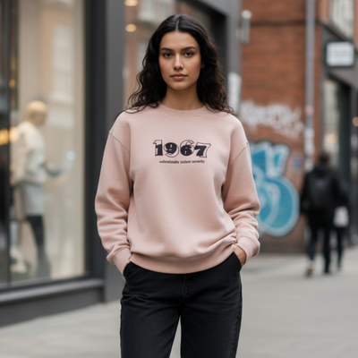 Beige crewneck sweatshirt with a 1967 front graphic worn by a woman