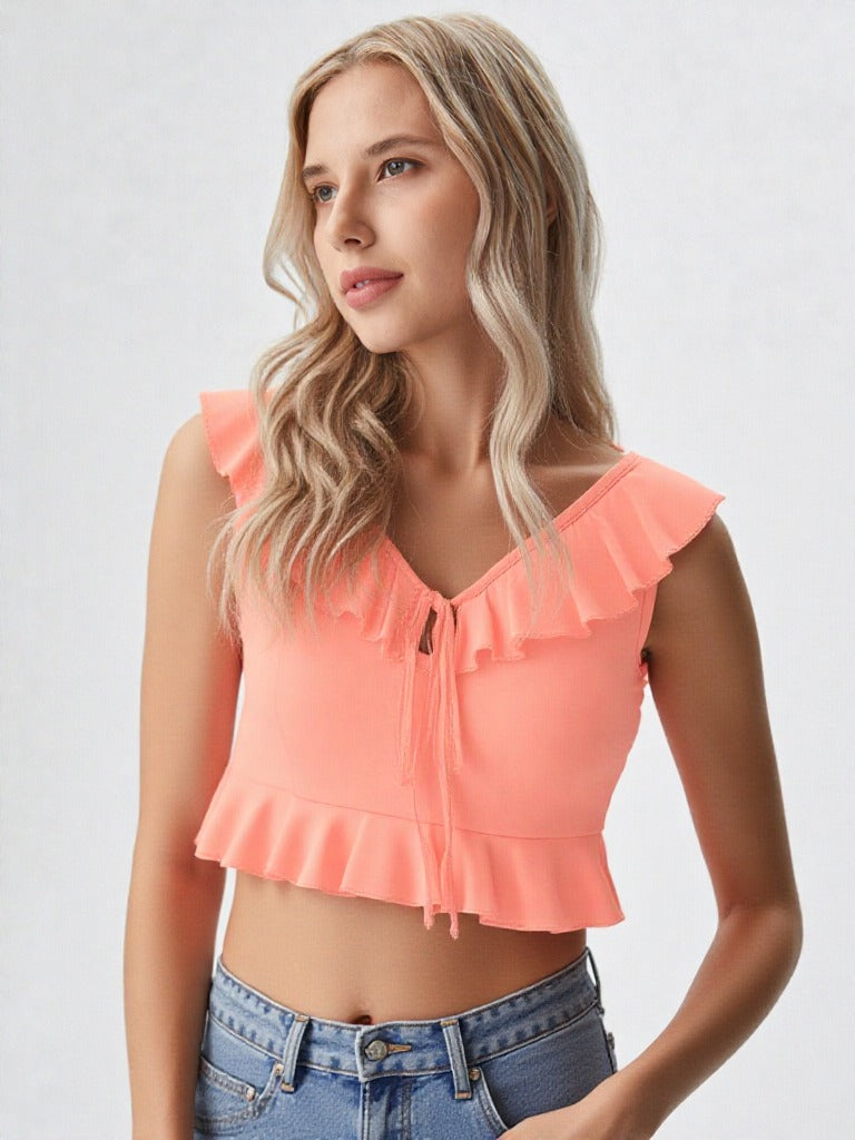 Close-up of woman wearing peach ruffle trim tie front crop top with denim jeans  