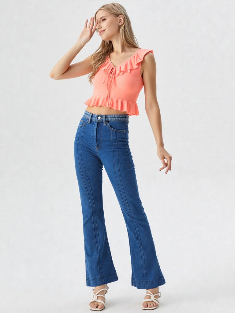 Close-up of woman wearing peach ruffle trim tie front crop top with denim jeans  