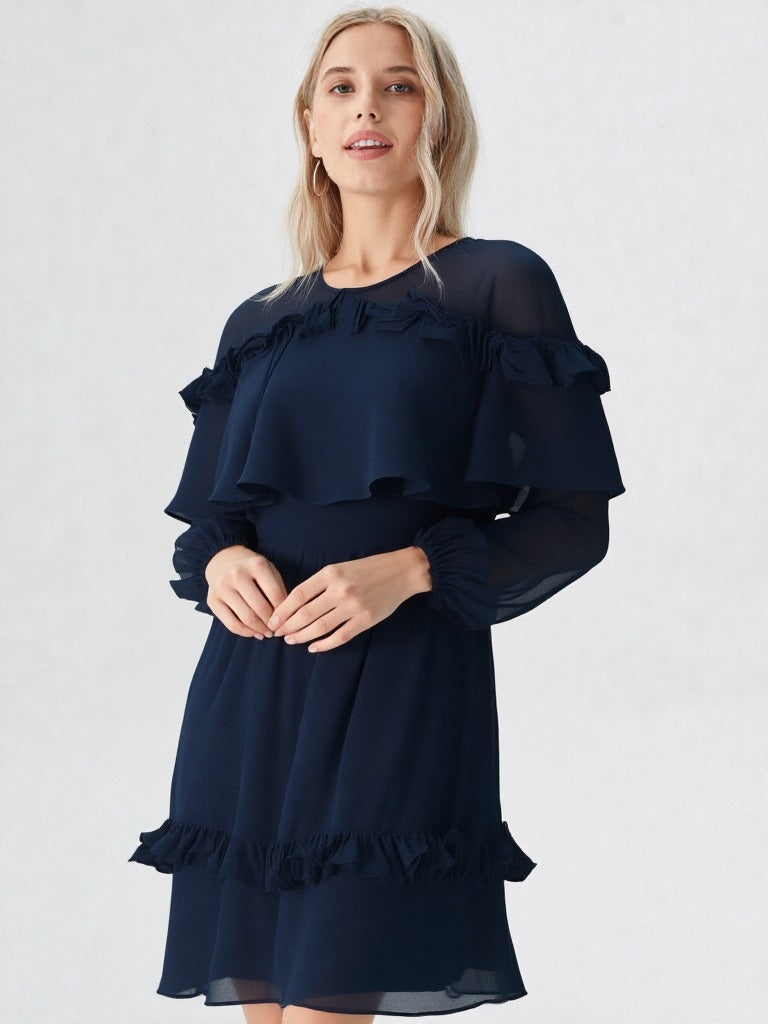 Woman wearing navy blue ruffle layer long sleeve dress with flowy hem  