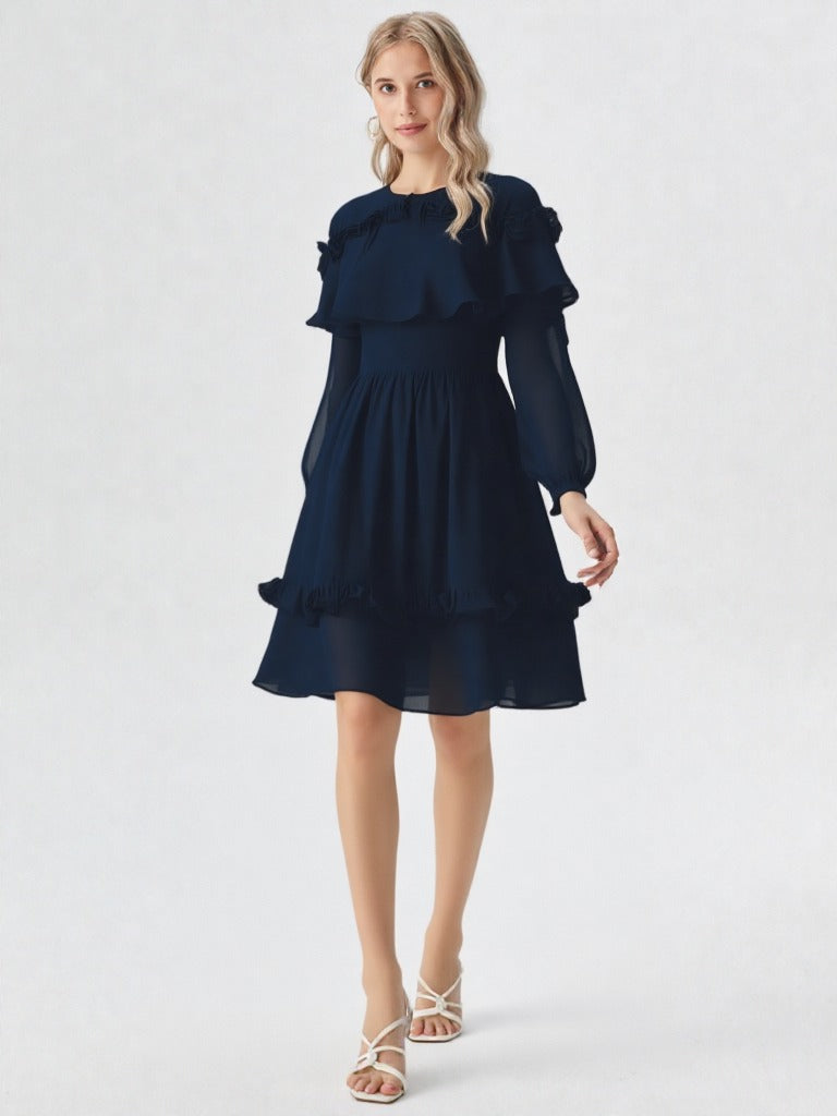 Woman wearing navy blue ruffle layer long sleeve dress with flowy hem  